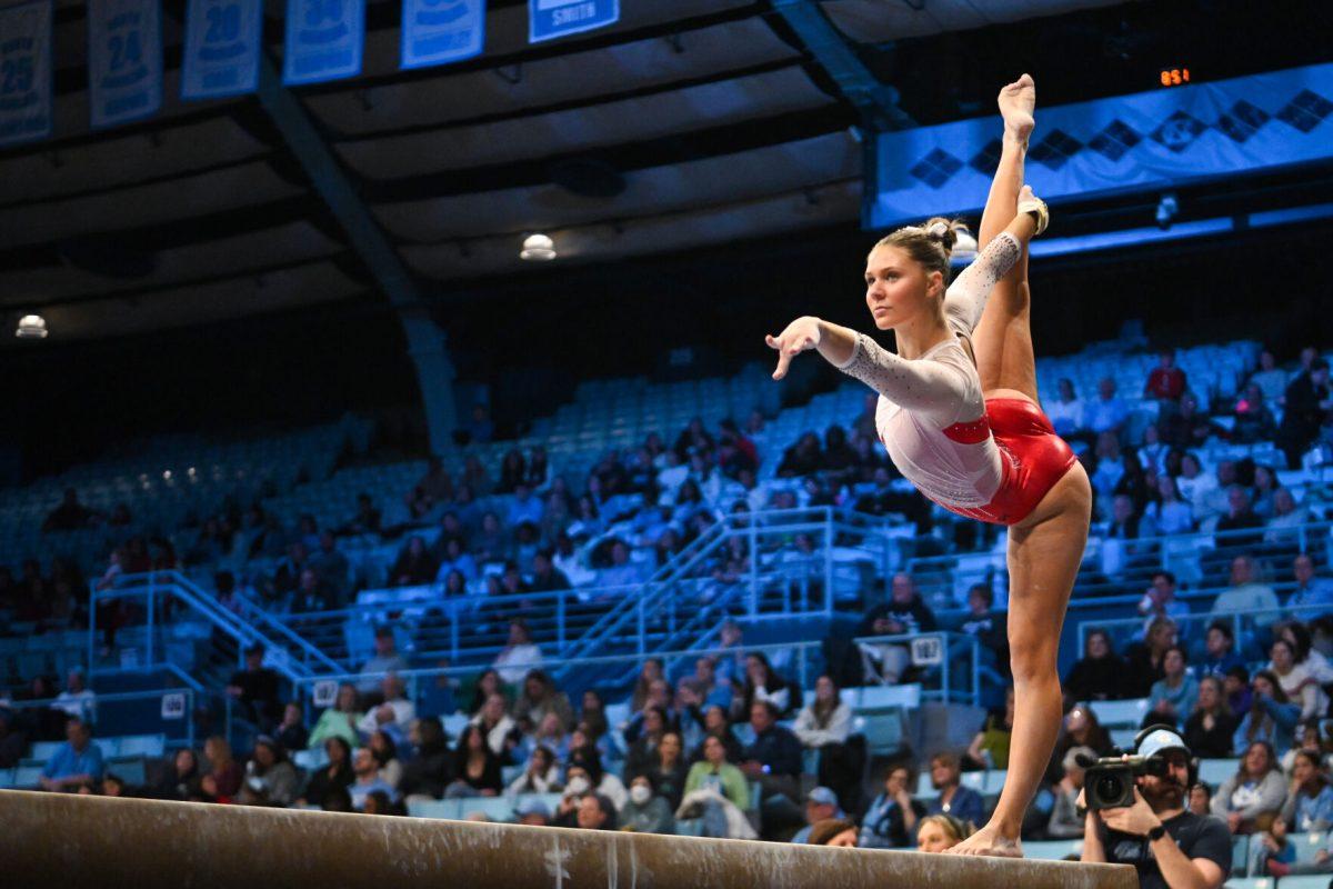 Freshman Caroline Volk poses on the beam during the meet against UNC-Chapel Hill in Carmichael Arena on Friday, Jan. 24, 2025. Volk earned a 9.750 on the balance beam. The Wolfpack beat the Tar Heels 196.350-195.925.