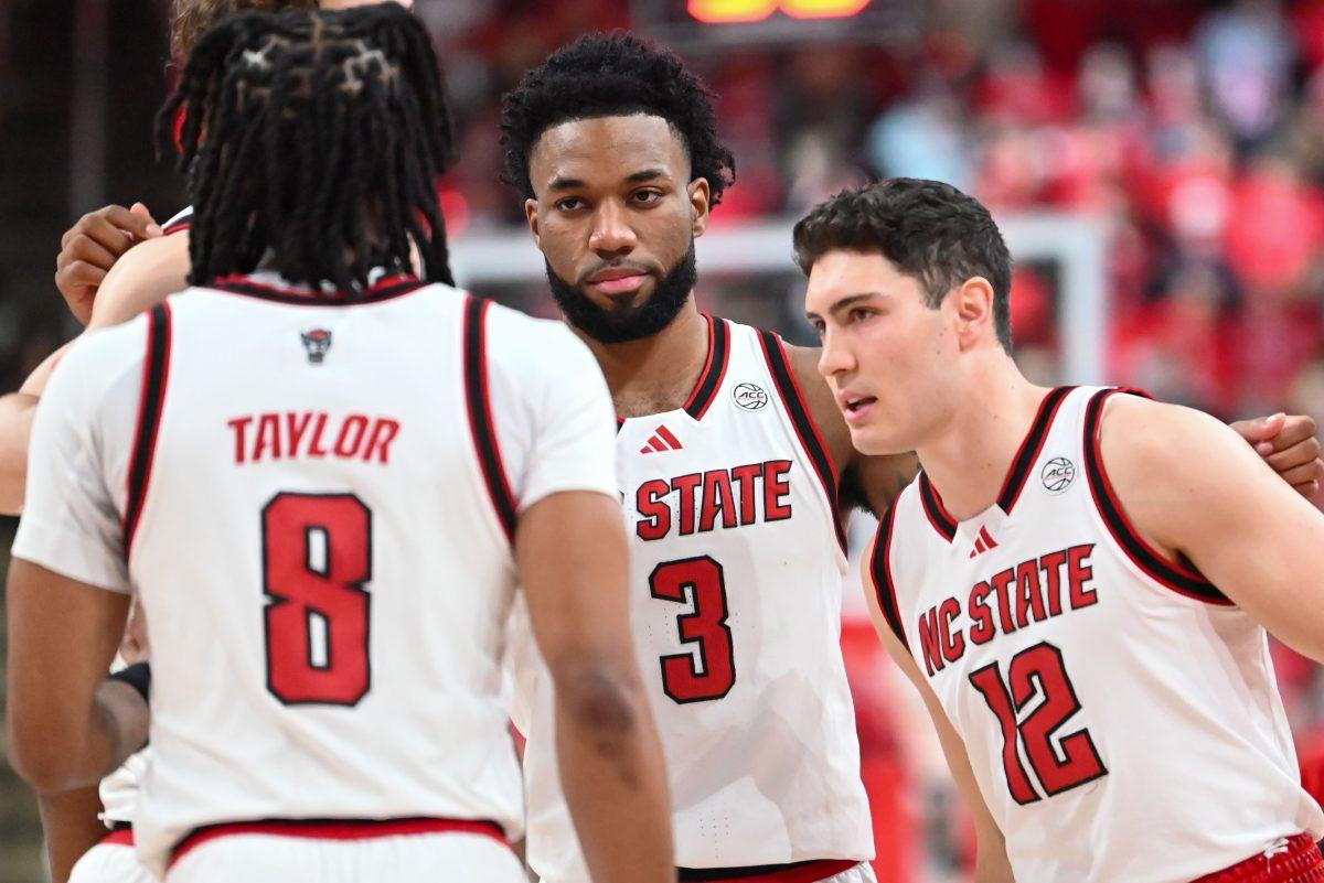 Senior guard Dontrez Styles looks at his team members in a team huddle before the game against UNC-Chapel Hill at the Lenovo Center on Saturday, Jan. 11, 2025. Styles scored seven points and had five rebounds. NC State lost 61-63.