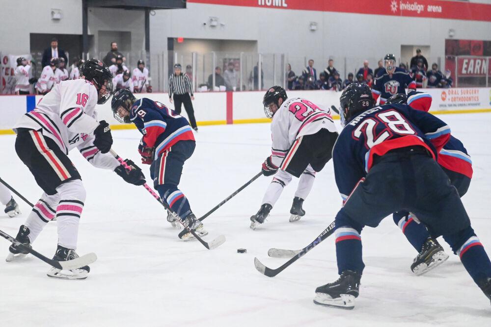 Freshman defenseman Tait Sawden moves to take the puck from the circle of opponents during the game against Liberty University at Invisalign Arena on Friday, Jan. 17, 2025. The Wolfpack lost to the Flames 5-4.