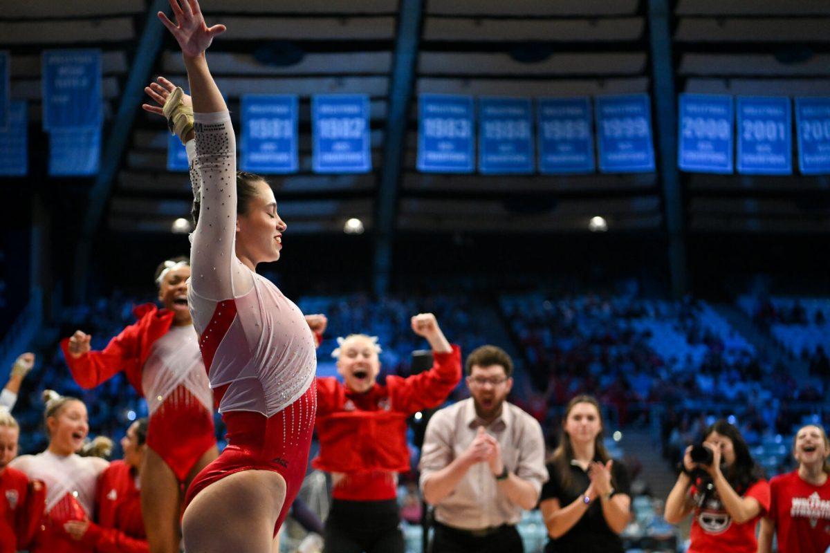Graduate student Chloe Negrete poses after dismounting the beam while the rest of the team cheers her on during the meet against UNC-Chapel Hill in Carmichael Arena on Friday, Jan. 24, 2025. Negrete earned a 9.900 on the balance beam. The Wolfpack beat the Tar Heels 196.350-195.925.