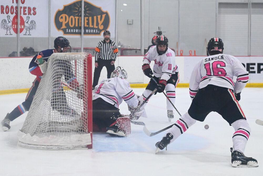 Junior goaltender Isaac Tawyer protects the goal with the help of two teammates during the game against Liberty University at Invisalign Arena on Friday, Jan. 17, 2025. The Wolfpack lost to the Flames 5-4.
