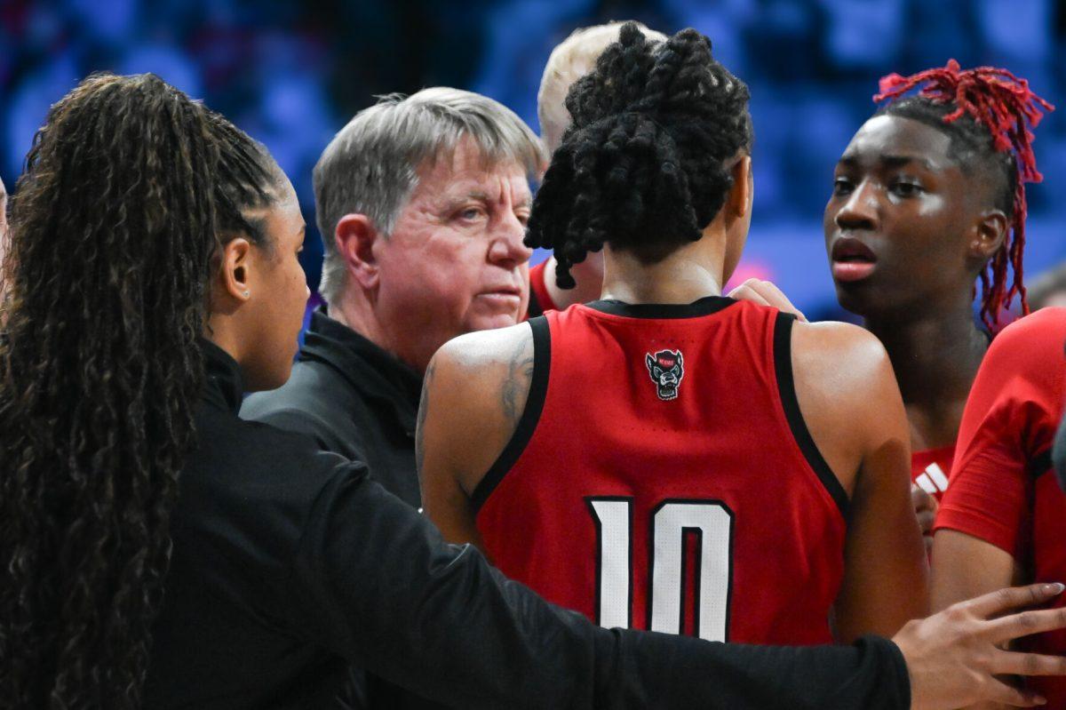 Senior guard Aziaha James and senior guard Saniya Rivers regroup with coaches during timeout in Carmichael In Carmichael Arena on Sunday, Feb. 16, 2025. James led the game&#160; with 16 overall scored points in the game. NC State lost the game 66-65