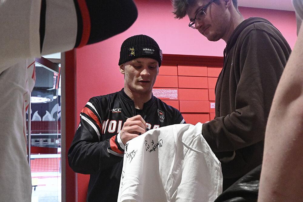 Redshirt senior Kai Orine signs a fan's shirt after the duel against Stanford in Reynolds Coliseum on Friday, Feb. 14, 2025. Orine lost the 133 bout 9-1. NC State beat Stanford 27-13.