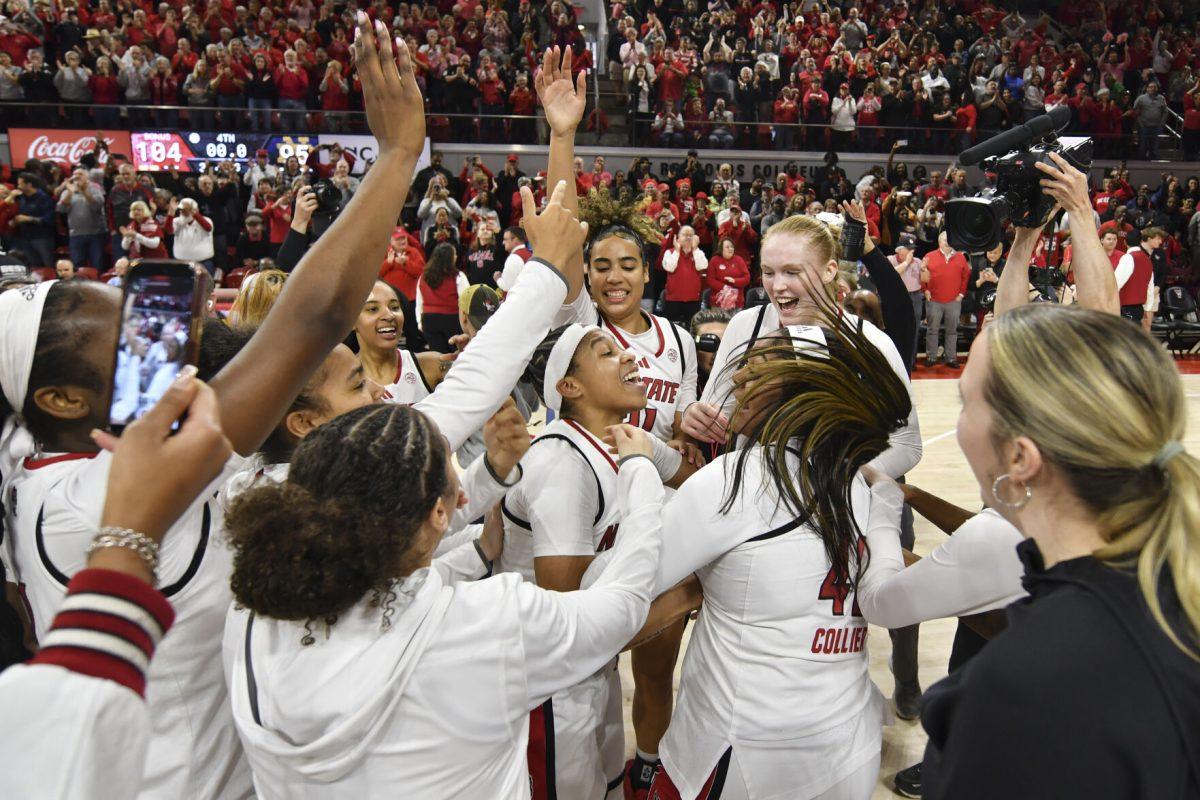 Sophomore guard Zoe Brooks celebrates in the middle of a circle of NC State women's basketball team players after the Wolfpack's game against the Fighting Irish in Reynolds Coliseum on Sunday, Feb. 23, 2025. Brooks scored 33 points, going 14-14 from the free throw line and recorded 10 rebounds. The Wolfpack beat the number one ranked Fighting Irish in double overtime 104-95.