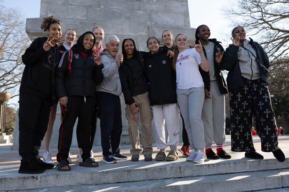 The NC State women's basketball team poses for a picture with Dr. Stafford at the Memorial Belltower on Sunday, Feb. 23, 2025. Dr. Stafford gave them the key to the Belltower and let them open it to celebrate their victory.