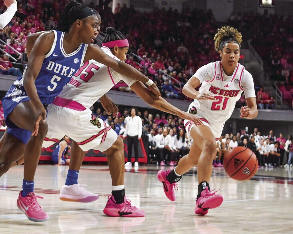 Graduate guard Madison Hayes and sophomore guard Zoe Brooks reach for the ball during the Play4Kay game against Duke at Reynolds Coliseum on Monday, Feb. 3, 2025. The Wolfpack beat the Blue Devils 89-83.