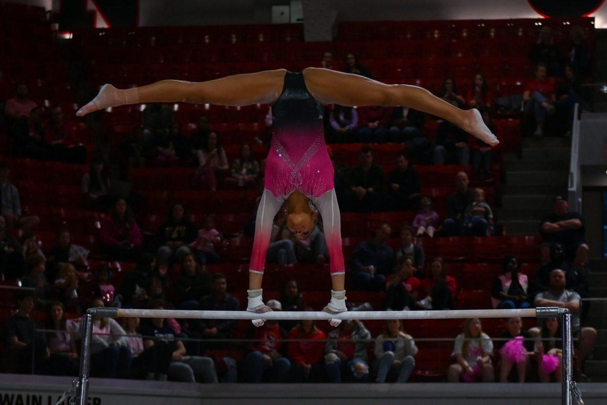 Freshman Ava Myers performs a split while rotating on the uneven bars during the meet against the University of Pittsburgh in Reynolds Coliseum on Saturday, Feb. 8, 2025. Myers' routine earned an average score of 9.775. The Wolfpack beat the Pitt Panthers 196.475 to 193.600.