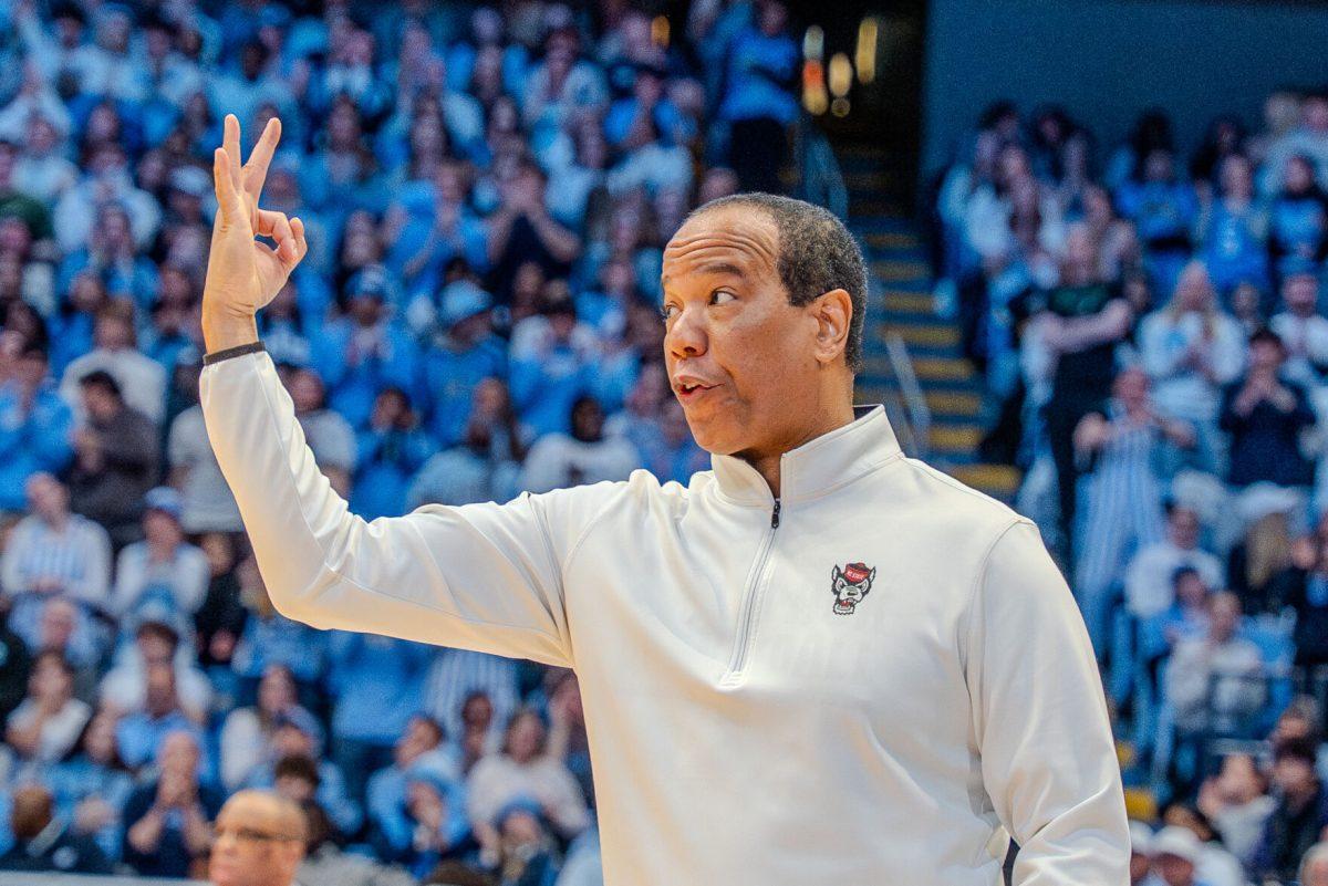 Coach Kevin Keatts holds up three fingers during the game against the University of North Carolina in the Dean E. Smith Center on Wednesday, Feb. 19, 2025. NC State lost the game 97-73.