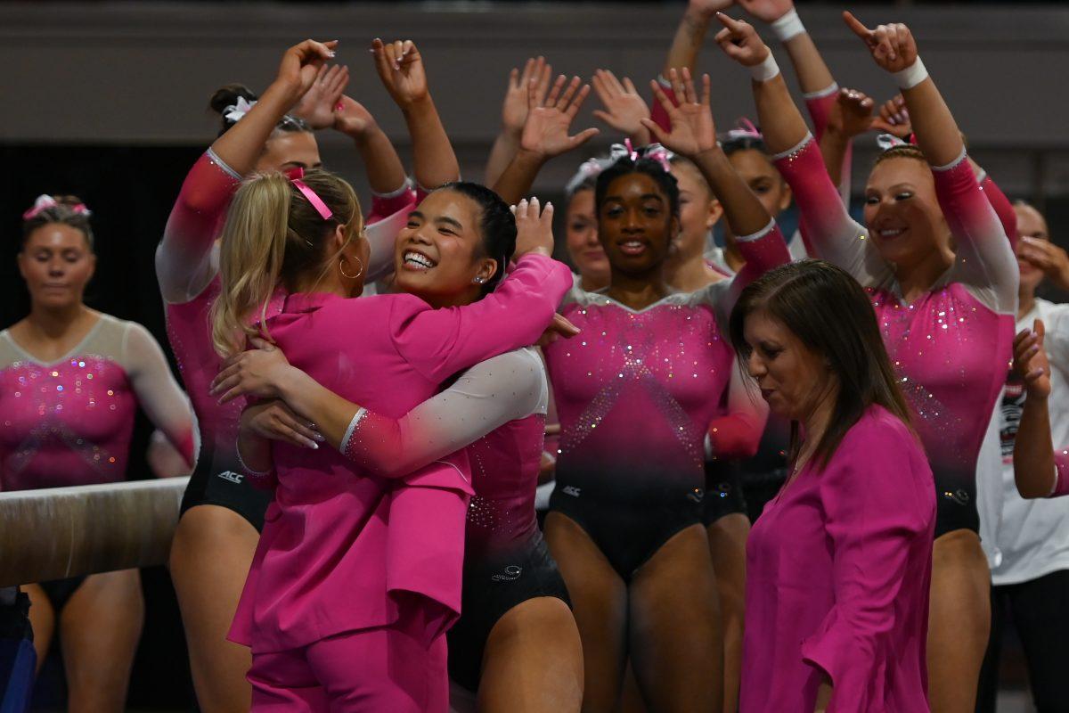 The NC State Women&#8217;s Gymnastics team celebrates after a successful event on the balance beam during the meet against the University of Pittsburgh in Reynolds Coliseum on Saturday, Feb. 8, 2025. The combined team score for the balance beam was 49.050. The Wolfpack beat the Pitt Panthers 196.475 to 193.600.