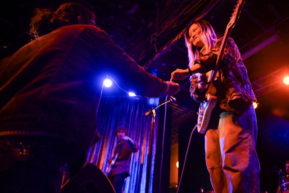 Katie Quinn, guitarist and vocalist of My Sister Maura, accepts a guitar pick from an audience member during the second night of WKNC's Double Barrel Benefit at Kings in Downtown Raleigh on Saturday, Feb. 15, 2025. This year marks the 21st annual benefit.