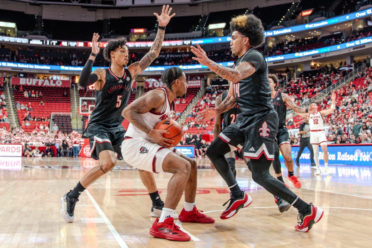 Senior guard Marcus Hill is surrounded by defenders during the game against University of Louisville in the Lenovo Center on Wednesday, Feb. 12, 2025. Hill scored 10 points and made three rebounds.&#160;NC State lost the game 91-61.