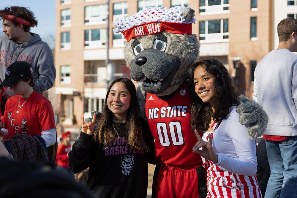 Mia Martinez, a third-year studying horticulture, and Banessa Santovo, a third-year studying nutrition, take a photo with Mr. Wuf at the Memorial Belltower on Sunday, Feb. 23, 2025. The crowd celebrated a women's basketball upset over Notre Dame, the #1 team in the nation.