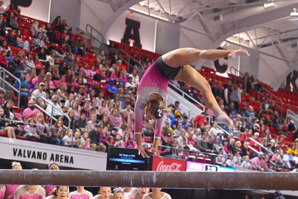 Senior Peyton Childs preforms a flip on the balance beam during the meet against Pittsburgh at Reynolds Coliseum on Saturday, Feb. 8, 2025. Childs scored a 9.800 on the balance beam. NC State beat Pittsburgh 196.475-193.600.