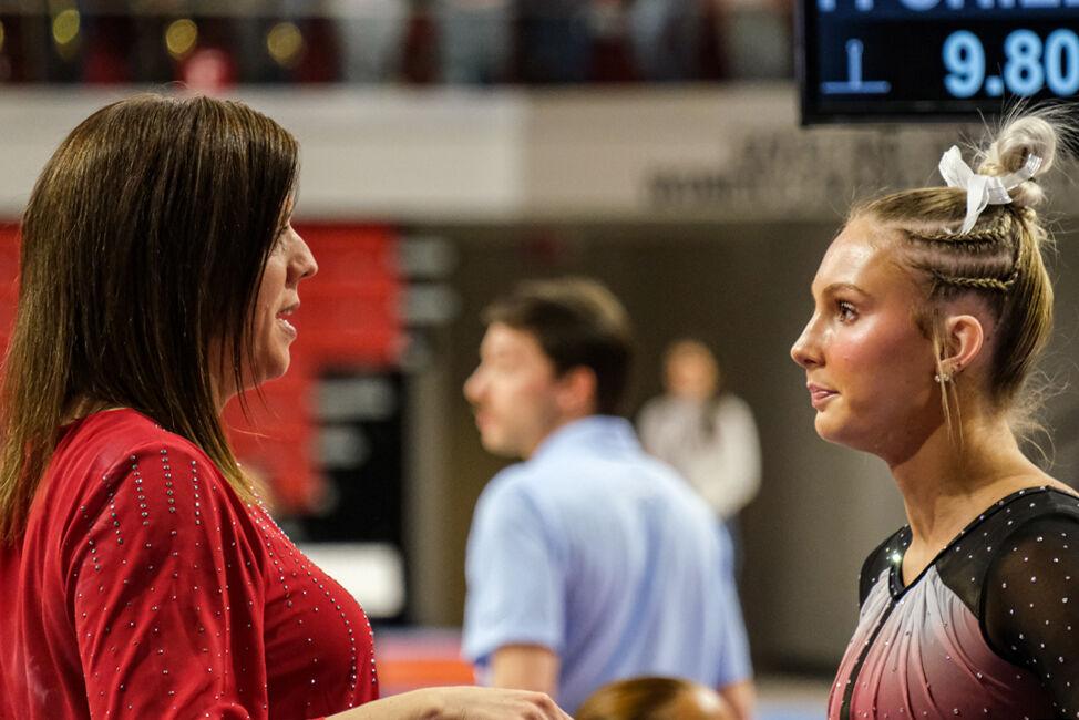 Sophomore Katie Harper talks with head coach Kim Landrus during the meet against UNC-Chapel Hill&#160;at Reynolds Coliseum on Friday, Feb. 21, 2025. NC State beat UNC 197.025-195.500.