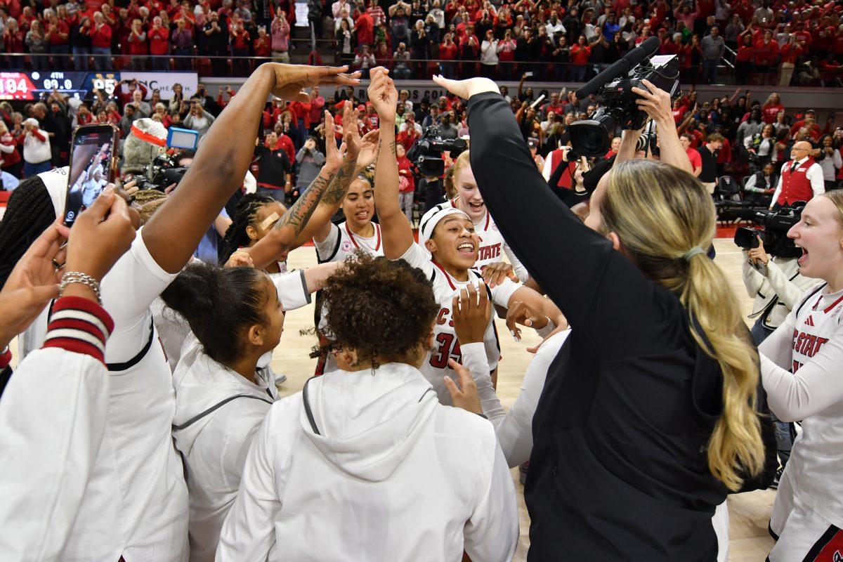 Sophomore guard Zoe Brooks celebrates in the middle of a circle of NC State women's basketball team players after the Wolfpack's game against the Fighting Irish in Reynolds Coliseum on Sunday, Feb. 23, 2025. Brooks scored 33 points, going 14-14 from the free throw line and recorded 10 rebounds. The Wolfpack beat the number one ranked Fighting Irish in double overtime 104-95.