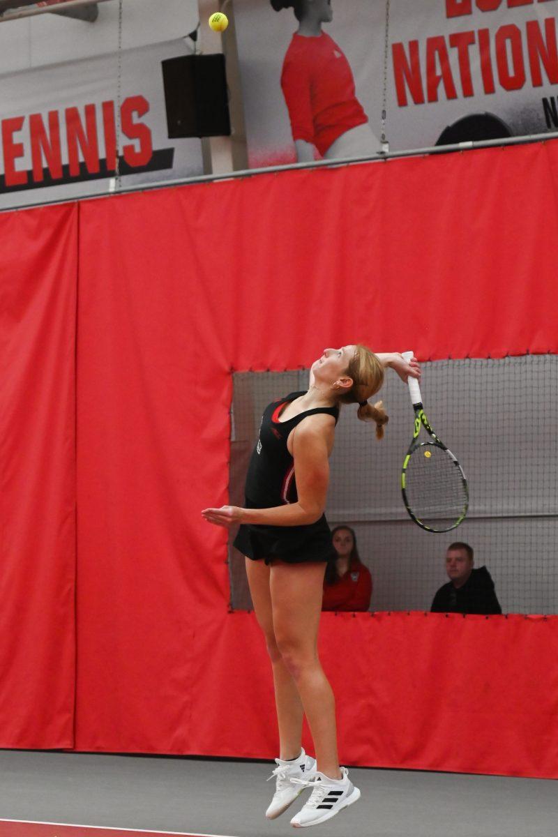 Sophomore Maddy Zampardo jumps into a serve during the match against Michigan at J. W. Isenhour Tennis Center on Friday, Feb. 14, 2025. Zampardo won her singles match 2-0. NC State beat Michigan 5-2.