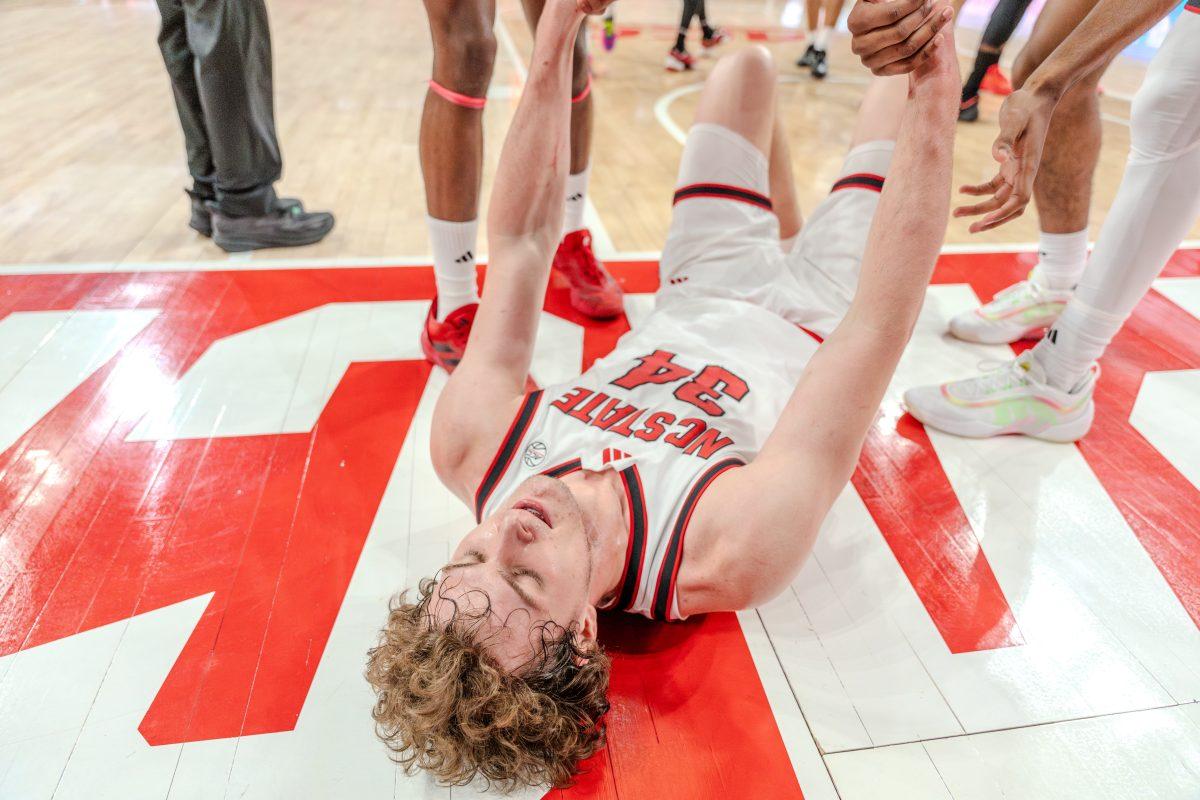 Senior forward Ben Middlebrooks is helped up by his teammates during the game against University of Louisville in the Lenovo Center on Wednesday, Feb. 12, 2025. Hill scored four points and made three rebounds.&#160;NC State lost the game 91-61.