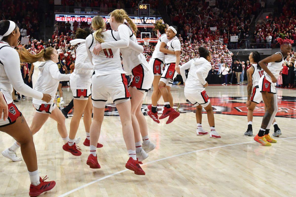 The NC State women's basketball team rushes the court after beating the number one ranked Notre Dame Fighting Irish in Reynolds Coliseum on Sunday, Feb. 23, 2025. Notre Dame hit a fourth quarter buzzer beater, but the Wolfpack beat the Fighting Irish 104-95 in double overtime.