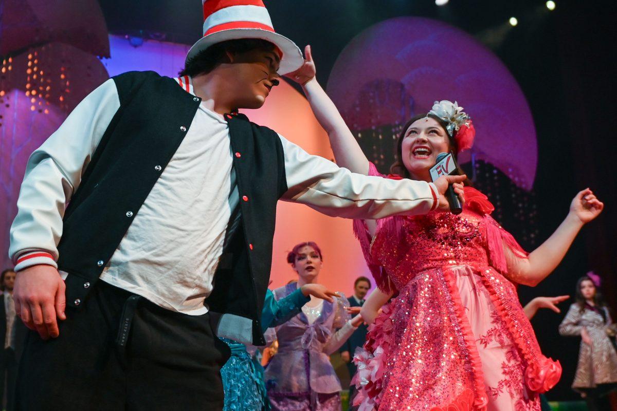 Owen Durso, a first-year studying nuclear engineering, playing the Cat in the hat while holding up a microphone for Brinley Carter, a third-year studying communication, who plays Mayzie during a performance of "Seussical" in Stewart Theater on Tuesday, Feb. 18, 2025. "Seussical" is runs from Feb. 20-23. The performance is based on various works by Dr. Seuss and is directed by Mia Self, assistant director of acting and directing at University Theater.