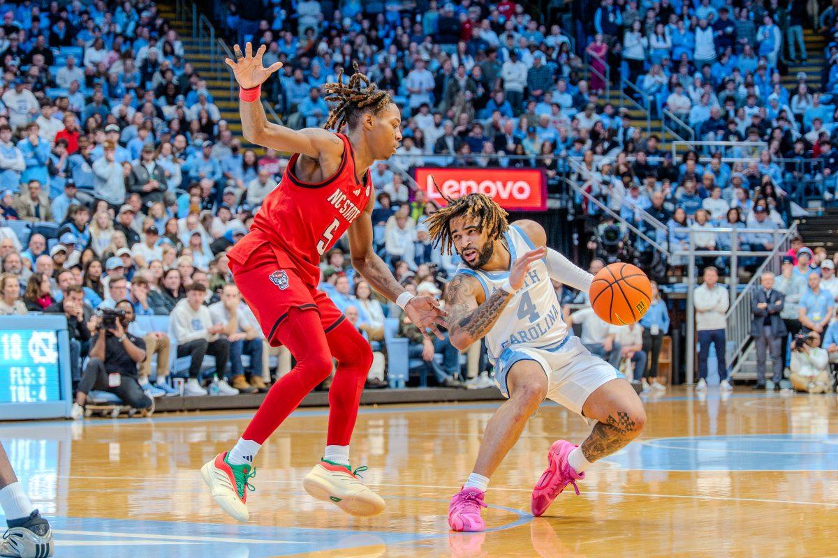 Freshman guard Trey Parker defends his opponent during the game against the University of North Carolina in the Dean E. Smith Center on Wednesday, Feb. 19, 2025. Parker scored four points and made one rebound. NC State lost the game 97-73.