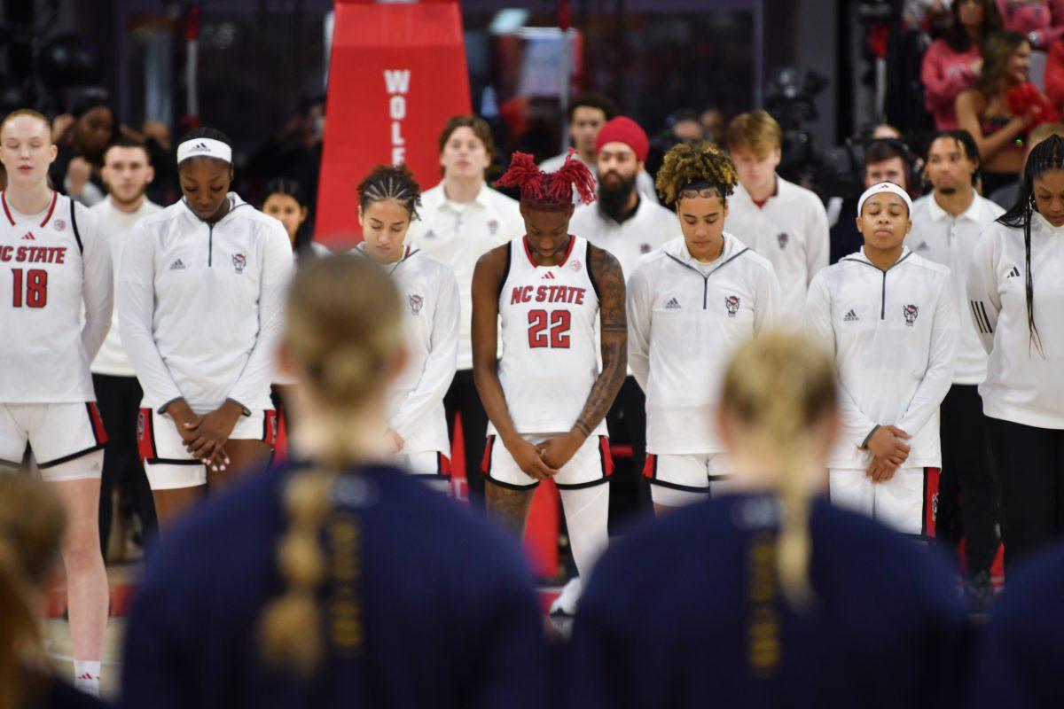 The teams line up for the playing of the national anthem before NC State's game against Notre Dame in Reynolds Coliseum on Sunday, Feb. 23, 2025. The Wolfpack beat the top ranked Fighting Irish in double overtime 104-95.