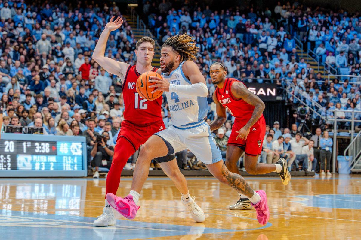 Graduate guard Michael O'Connell attempts to defend his opponent during the game against the University of North Carolina in the Dean E. Smith Center on Wednesday, Feb. 19, 2025. O'Connell scored eight points and made two rebounds. NC State lost the game 97-73.