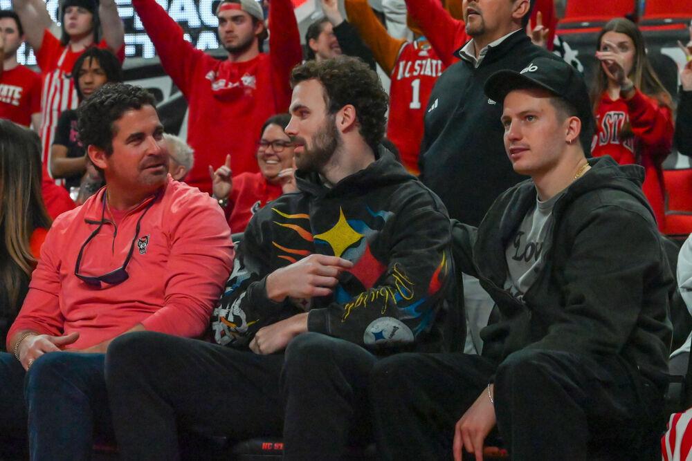 Former NC State football players Payton Wilson and Thayer Thomas chat with a fan during the game against Boston College in the Lenovo Center on Saturday, Feb. 15, 2025. NC State beat Boston College 70-62.