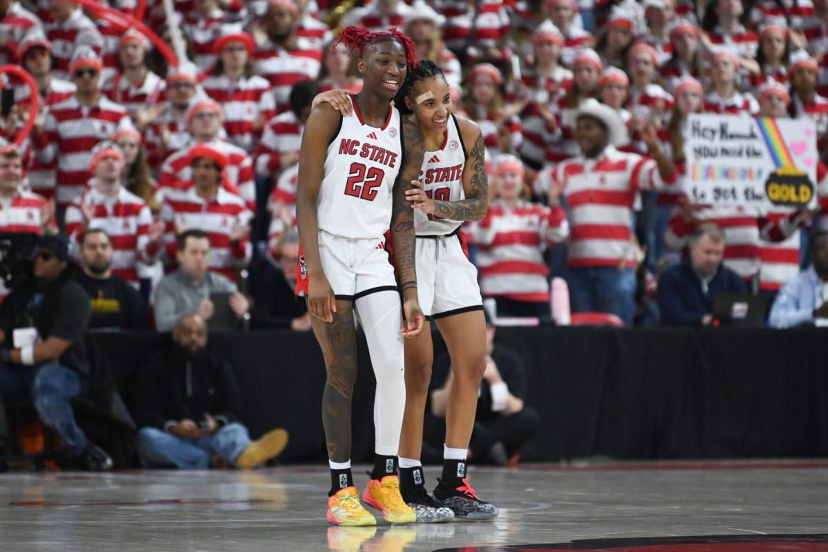 Senior guard Saniya Rivers and senior guard Aziaha James hug during the second overtime period of NC State's game against Notre Dame in Reynolds Coliseum on Sunday, Feb. 23, 2025. The Wolfpack beat the Fighting Irish 104-95.