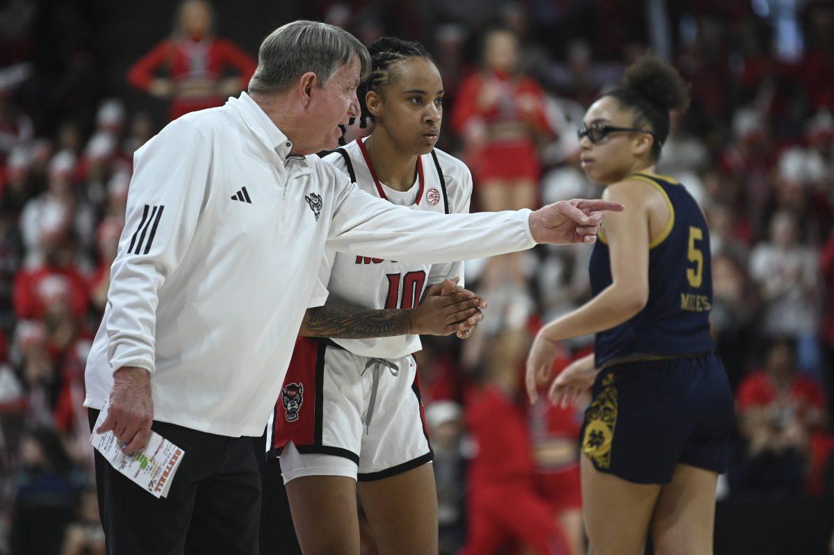 Head coach Wes Moore talks to senior guard Aziaha James during the game against the Notre Dame Fighting Irish in Reynolds Coliseum on Sunday, Feb. 23, 2025. James scored 20 points and recorded five rebounds and two assists. The Wolfpack beat the number one ranked Fighting Irish 104-95 in double overtime.