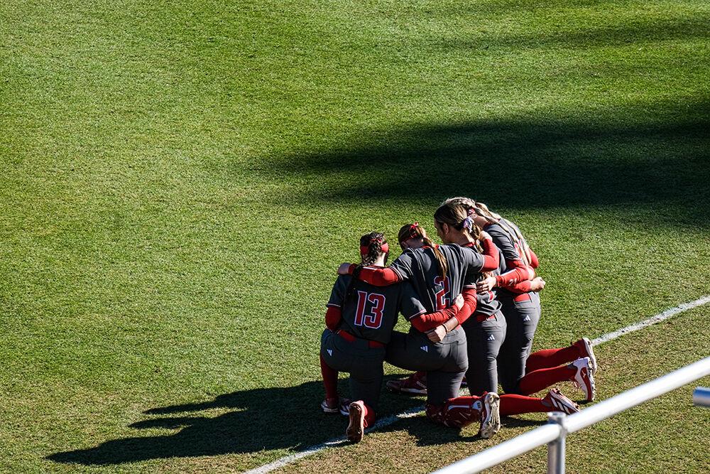 Members of the NCSU softball team pray during the game against UNC-Wilmington at Dail Softball Stadium on Feb. 28, 2025. NC State lost to UNC-Wilmington 5-4.