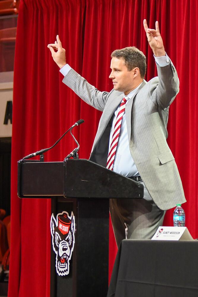 Will Wade, the new head coach of NC State men's basketball, holds up a "wolfie" before the Q&amp;A portion of his press conference inside Reynolds Coliseum on Tuesday, March 25, 2025. Wade is the Wolfpack's 21st men's basketball coach, following after former coach Kevin Keatts.