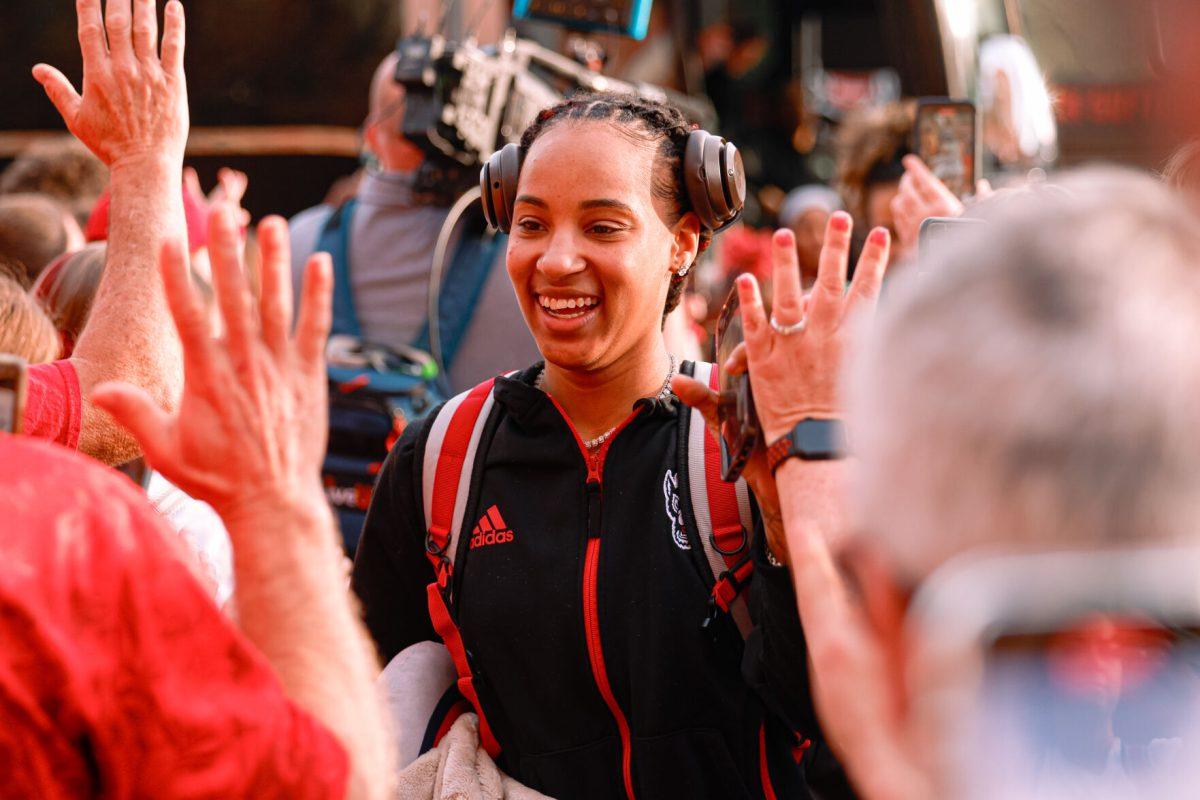 Senior guard Aziaha James high-fives the fans during their welcome back to Reynolds Coliseum on Saturday, March 29. James played in all 35 games during her senior season averaging 17.9 points per game.
