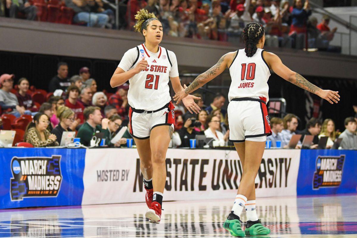 Graduate guard Madison Hayes (left) high-fives senior guard Aziaha James (right) after scoring during the first round game of the NCAA Tournament against Vermont in Reynolds Coliseum on Saturday, March 22, 2025. The Wolfpack beat the Catamounts 75-55.