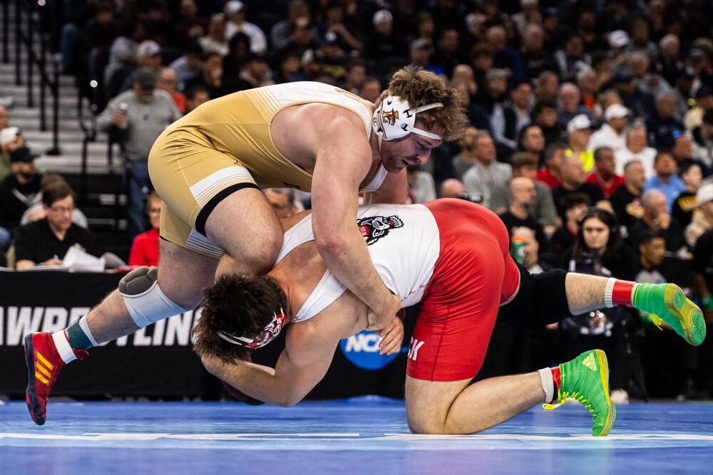 Redshirt junior Isaac Trumble grabs former NC State wrestler Owen Trephan's leg during their bout in the NCAA Wrestling Championship Tournament on Saturday, March 22, 2025. Trumble placed fourth and Trephan placed fifth in the heavyweight class. NC State finished the tournament in eighth place with 46.5 points.