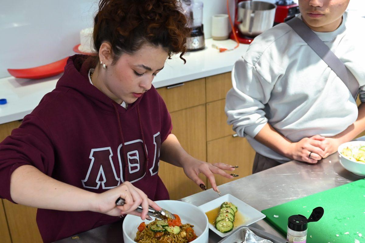 Valeria Gonzalez Perez, a fourth-year studying zoology, sets the final plate with her team's dish during the MGC Chopped: Cooking Competiton at Carmichael Gym on Wednesday, March 26, 2025. Teams were give one hour to make a dish using ingredients they were introduced to at the beginning of the challenge.