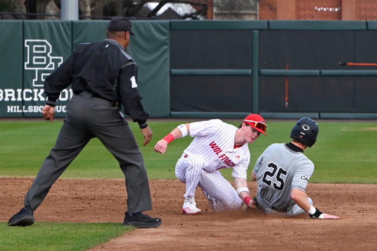 Sophomore infielder Luke Nixon attempts to tag a runner out during the game against Campbell on Doak Field at Dail Park on Wednesday, March 5, 2025. The Wolfpack defeated the Fighting Camels 11-1.