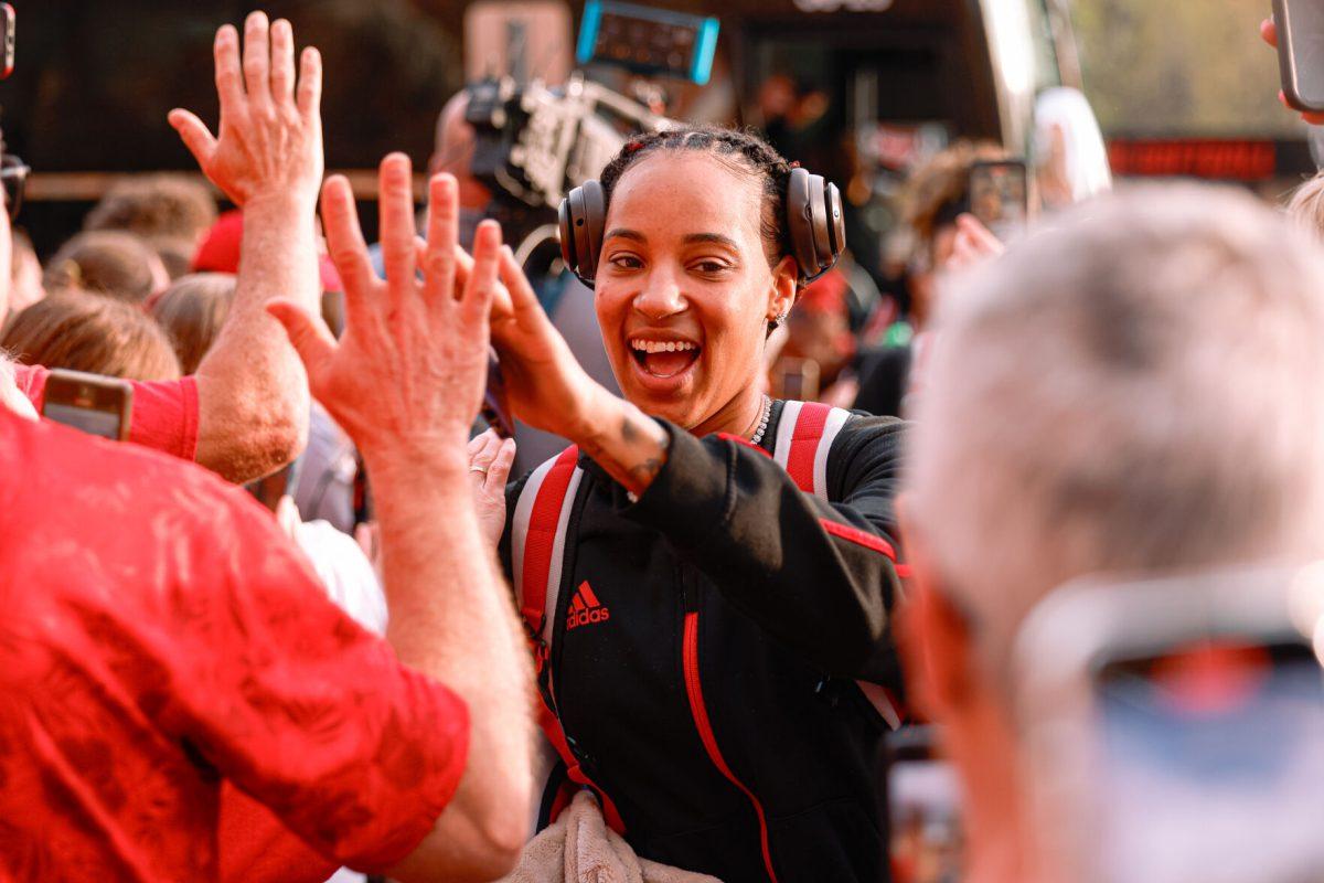 Senior guard Aziaha James high-fives the fans during their welcome back to Reynolds Coliseum on Saturday, March 29. James played in 35 games during her senior season shooting 44.5% from the field.