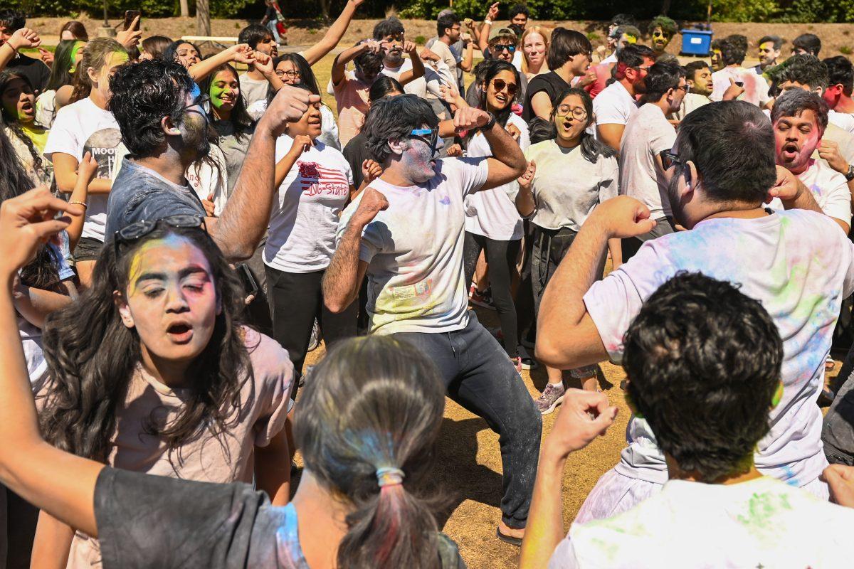 A dance circle forms during Holi at Stafford Commons on Saturday, March 22, 2025. Holi is known as the Festival of Colors, and celebrates spring by throwing colored powder.