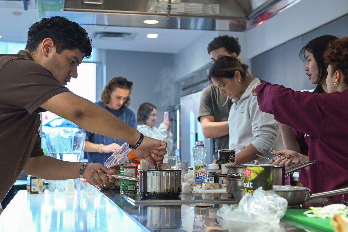 Students cook their dishes during the MGC Chopped: Cooking Competiton at Carmichael Gym on Wednesday, March 26, 2025. The teams were given one hour to complete the challenge and had to incorporate at least one of the three surprise ingredients: pomegranate seeds, coconut milk or ramen noodles.