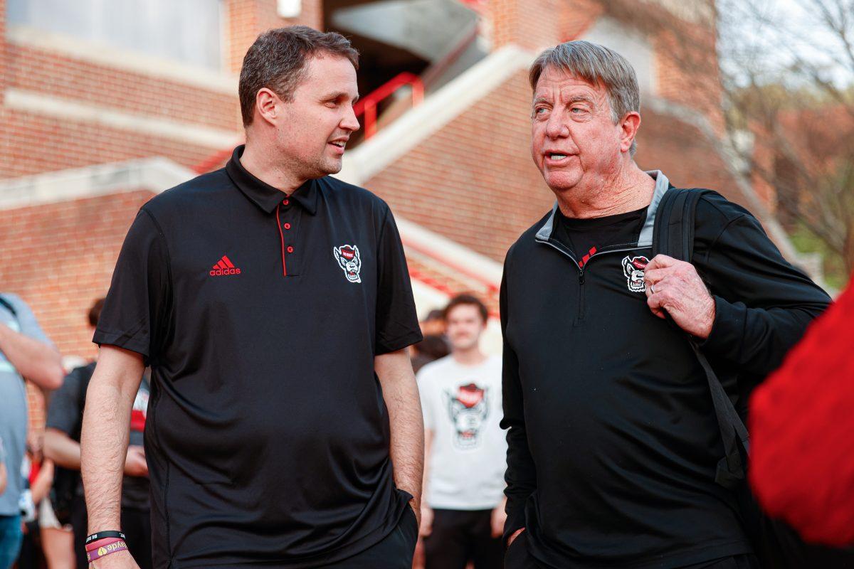 Newly hired men's basketball coach Will Wade talks to women's basketball head coach Wes Moore during the team's welcome back to Reynolds Coliseum on Saturday, March 29.