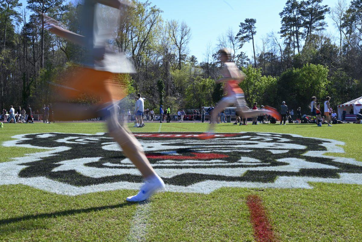 Track and field athletes warm up on the field during the Raleigh Relays track meet at the Derr Track and Field Facility on Thursday, March 27, 2025.