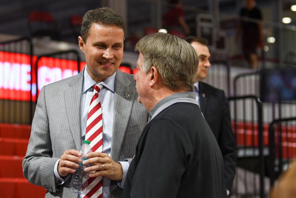 Will Wade, the new head coach of NC State men's basketball, smiles while speaking to women's basketball coach Wes Moore during a press conference discussing Wade's hiring inside Reynolds Coliseum on Tuesday, March 25, 2025. Wade will serve as the new men's basketball coach after having been at McNeese State.