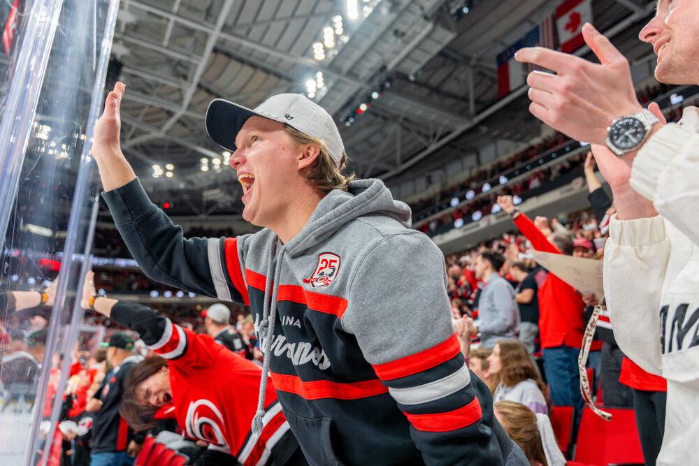 A Carolina Hurricanes fan slams their hand into the glass during the game against the Tampa Bay Lightning at the Lenovo Center on Tuesday, March 11, 2025. The Hurricanes beat the Lightning 4-1.