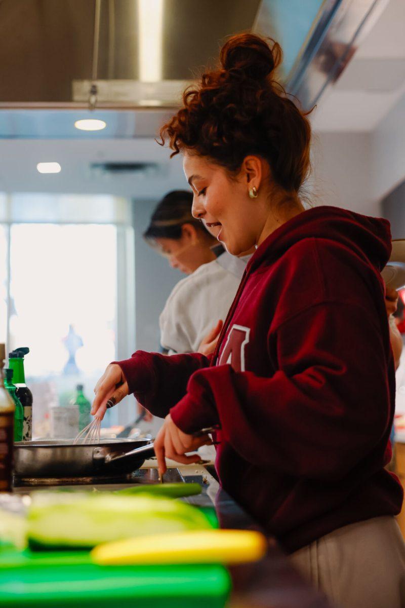Valeria Gonzalez Perez, fourth-year studying Zoology talks to her other teammates while stirring her dish during the MGC Chopped: Cooking Competition at Carmichael gym on Wednesday, March 26, 2025. Perez was on team two which ended up taking the win by one point 67-66.