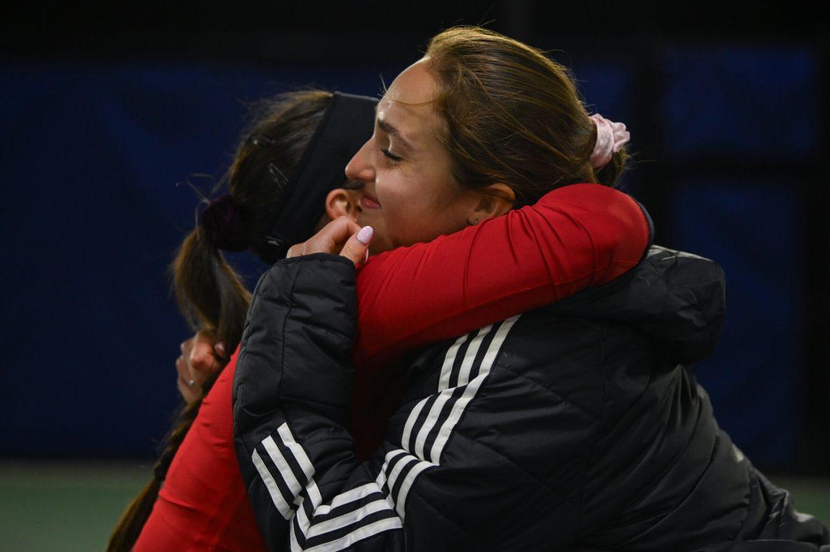 Freshman Michaela Laki (left) hugs sophomore Jasmine Conway (right) in celebration of Laki's single match victory during the match against Duke at Ambler Tennis Stadium on Friday, March 21, 2025. NC State fell to Duke 3-4.