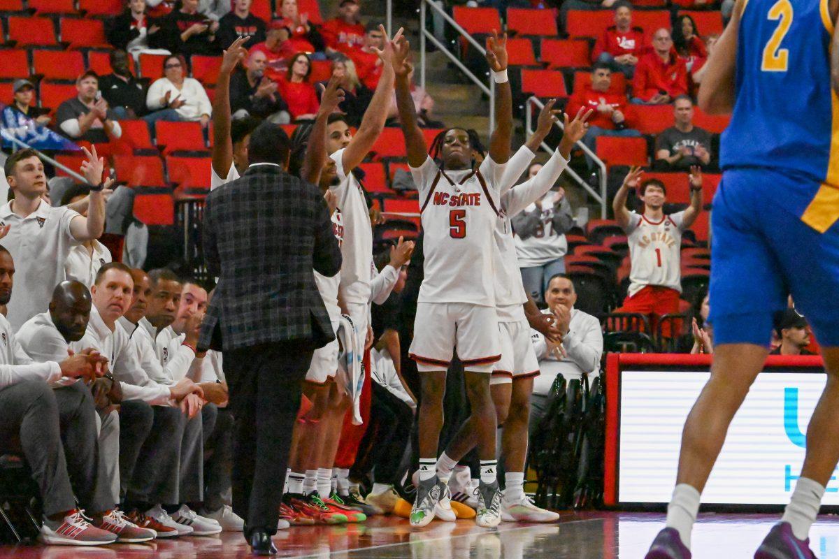 Freshman guard Trey Parker and NC State bench celebrates the 3-pointer during the game against Pitt in the Lenovo Center on Wednesday, March 5, 2025. The Wolfpack beat the Panthers 71-63.
