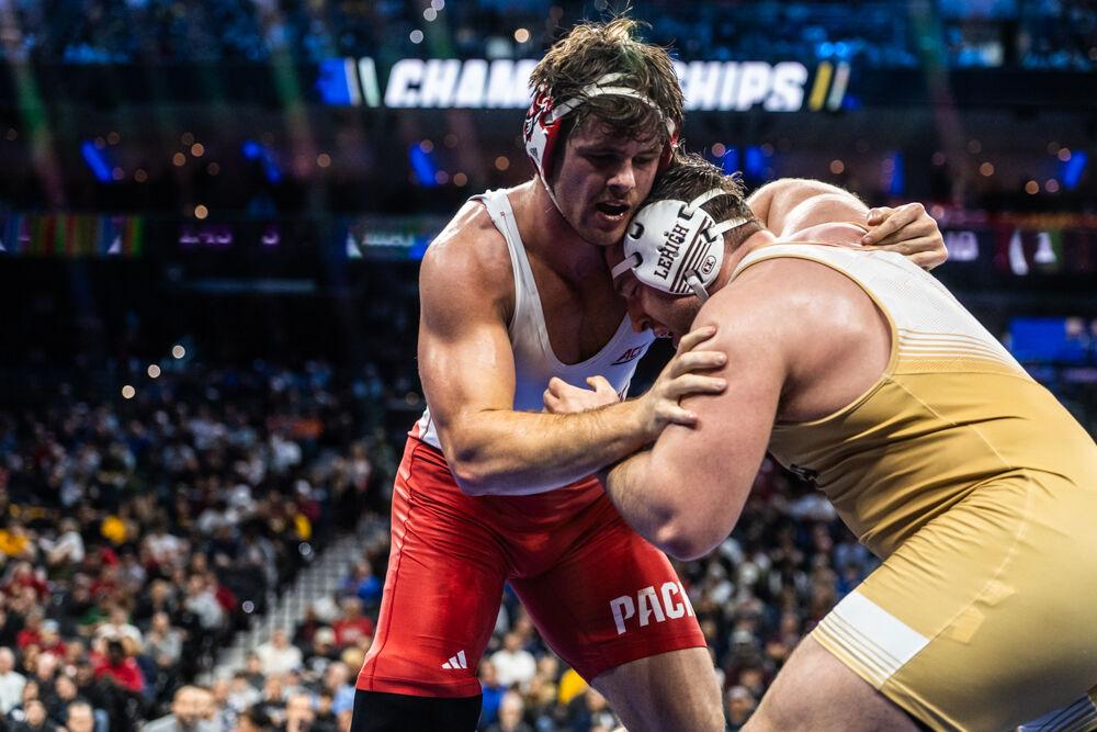 Redshirt junior Isaac Trumble grapples with former NC State wrestler Owen Trephan's leg during their bout in the NCAA Wrestling Championship Tournament on Saturday, March 22, 2025. Trumble placed fourth and Trephan placed fifth in the heavyweight class. NC State finished the tournament in eighth place with 46.5 points.