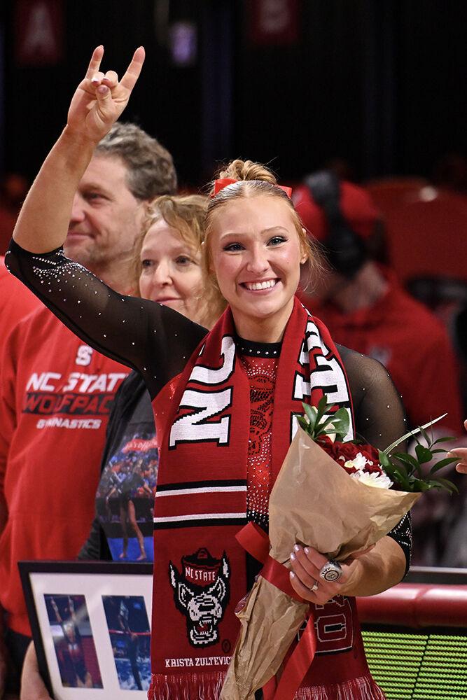 Graduate student Krista Zultevicz holds up a &#8220;wolfie&#8221; after the meet against Ohio State in Reynolds Coliseum on Friday, March 7, 2025. Zultevicz scored 9.825 on the vault and 9.775 in the floor exercise. NC State beat Ohio State 197.000-196.325.