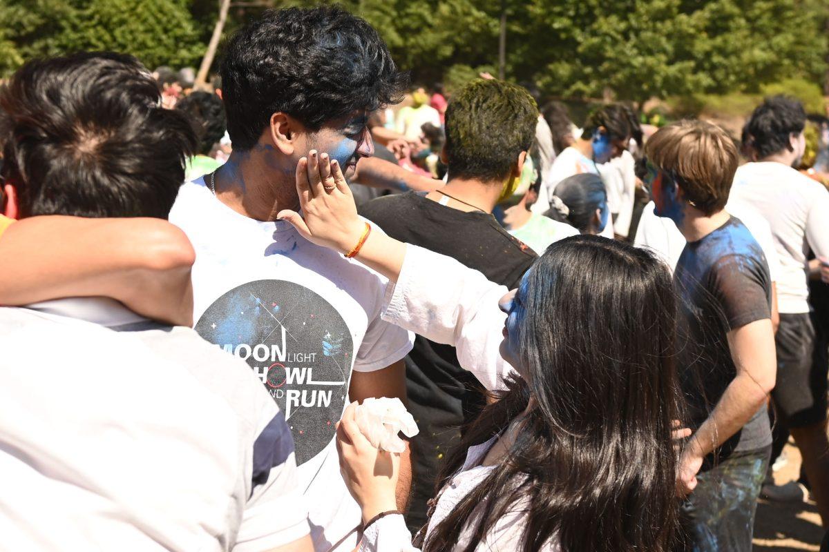 Sanith Rao, a graduate student studying financial math, gets colored by a friend during Holi at Stafford Commons on Saturday, March 22, 2025. Holi is known as the Festival of Colors, and celebrates spring by throwing colored powder.