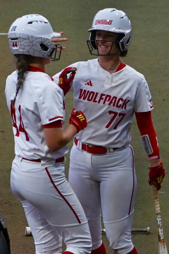 Senior infielder Hannah Goodwin holds up a "four" for senior infielder Taylor Ensley after she scored during the game against UNC-Wilmington in Dail Softball Stadium on Saturday, March 1, 2025. Ensley scored one run. The Wolfpack beat the Seahawks 14-1.